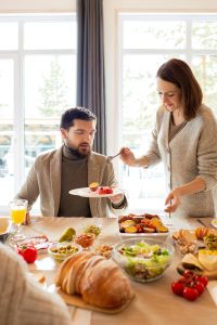 Warm setting avec des personnes profitant d'un petit-déjeuner à l'intérieur, mettant en avant du pain frais et des fruits.