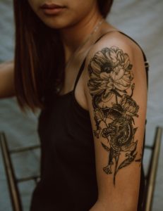 Side view de profil d'une femme anonyme avec une image de dragon et de fleur sur la main