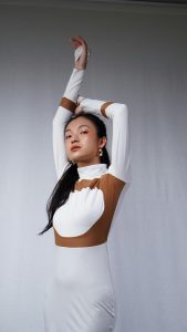 Elegant portrait de mode d'une femme en robe longue moderne posant avec confiance.