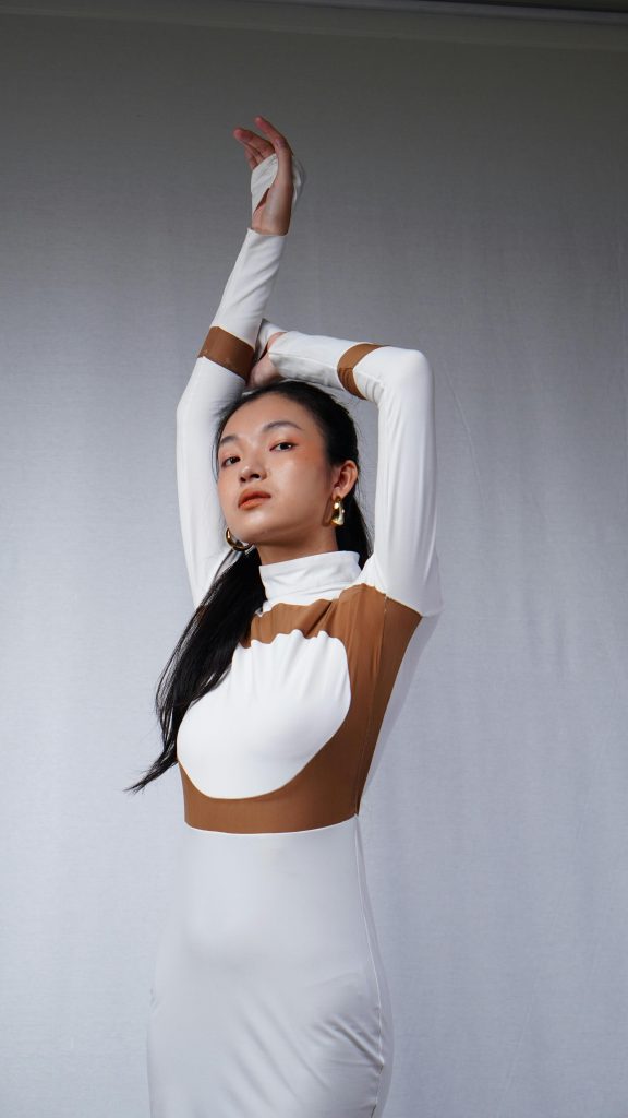 Elegant portrait de mode d'une femme en robe longue moderne posant avec confiance.