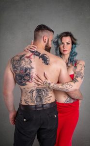 Couple s'enlaçant, mettant en valeur des tatouages frappants dans un cadre studio