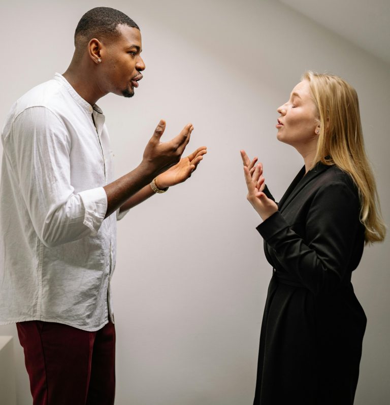 A couple engaged in a heated argument indoors, expressing strong emotions and gestures. Un couple engagé dans une dispute animée en intérieur, exprimant des émotions et des gestes intenses.