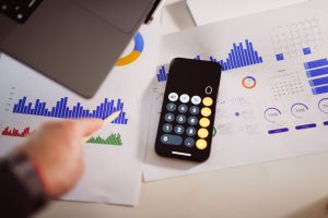 Business analytics setup with calculator, graphs, and laptop, showcasing financial insights. Configuration d'analyse commerciale avec calculatrice, graphiques et ordinateur portable, mettant en avant les insights financiers.